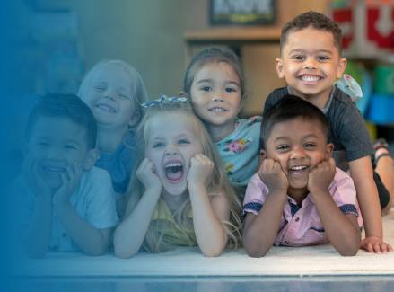 Children smiling and laying in a pyramid formation